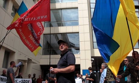 Ukrainian protesters hold banners outside the tax ministry in Kiev on 23 May 2014